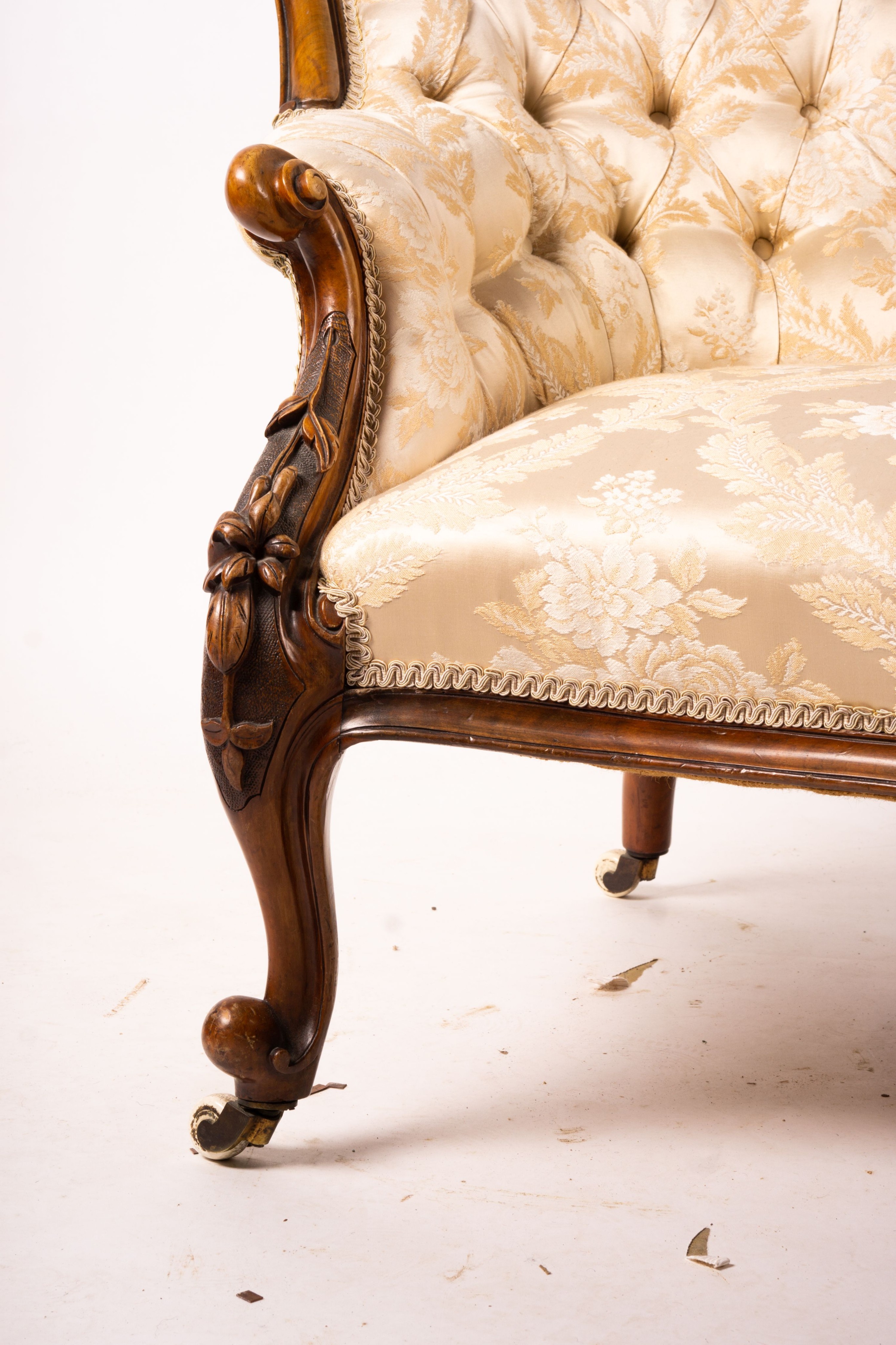 A late Victorian carved walnut three piece salon suite, comprising chaise longue, open armchair and nursing chair